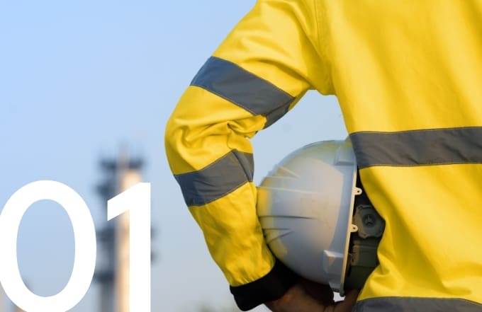Construction worker in a high-visibility safety jacket holding a hard hat.